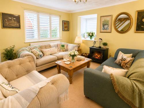 a living room with two couches and a fireplace at Two Ducks Cottage by NewFo dot Rest in Lyndhurst
