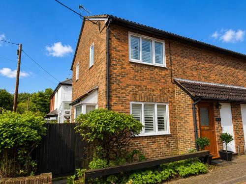 a brick house with white windows and a fence at Two Ducks Cottage by NewFo dot Rest in Lyndhurst
