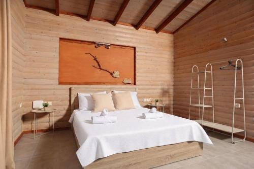a bedroom with a bed in a wooden wall at Hilltop Chalet 5 in Hanioti