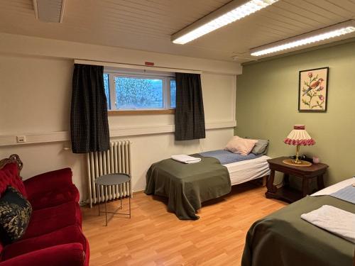 a bedroom with a bed and a couch and a window at Varpholt House Apartments & Rooms in Akureyri