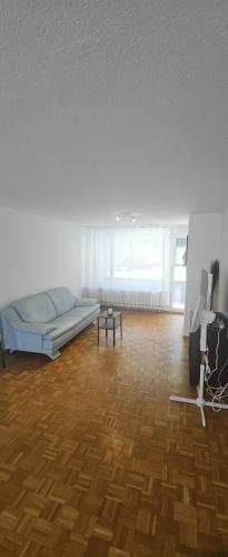 a white room with a bed and a wooden floor at Sensi Living Dorf in Freienbach