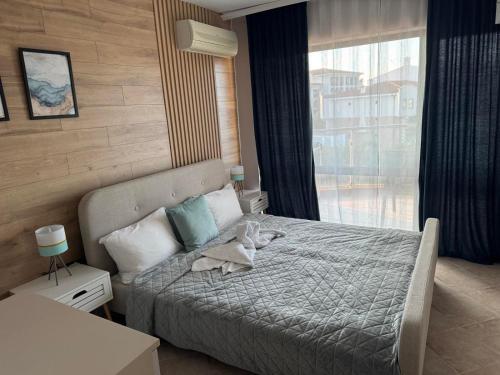 a bedroom with a bed and a large window at Sun Sea Resort in Ravda