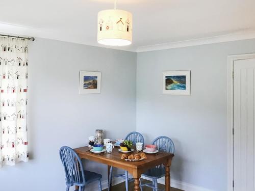 a dining room with a wooden table and chairs at Buzzards - 8235 in Bridport