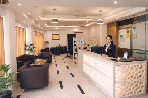 a woman standing at a counter in a lobby at Hotel Apple Park - A Boutique Hotel with Free Airport Tranfer in New Delhi
