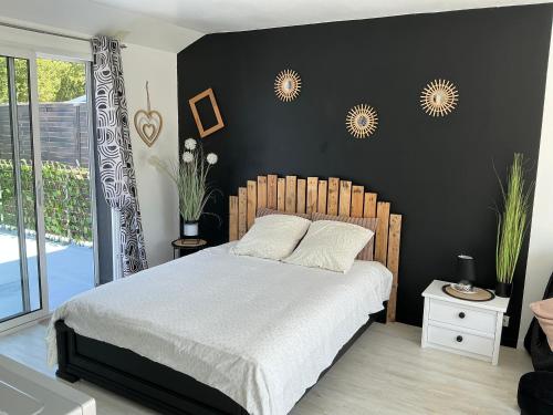 a bedroom with a bed and a black wall at Les Terasses d Eole in Assigny