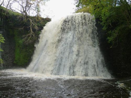 a waterfall in the middle of a river at Aysgill Cottage in Hawes