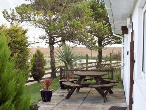 a picnic table and benches on a patio at Fistral in Saint Merryn