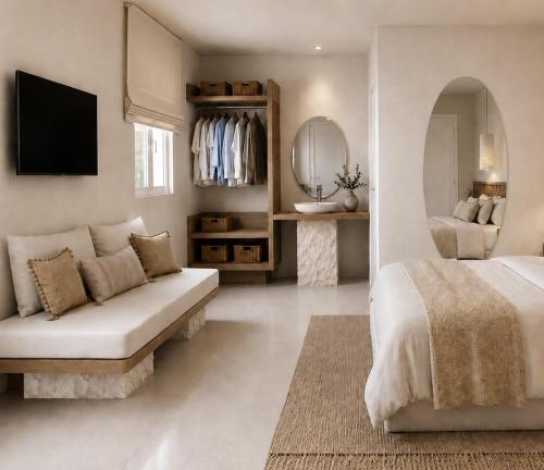 a white bedroom with a couch and a mirror at Sea Lily Suites Milos in Paleochori