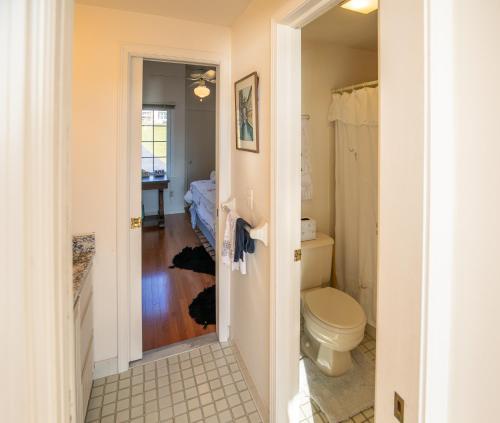 a bathroom with a toilet and a bedroom at Lovely Lakeside Lodge in Canandaigua