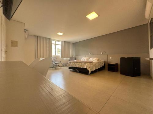 ein Schlafzimmer mit einem Bett, einem Tisch und Stühlen in der Unterkunft Hotel Picpo in Ponte Nova