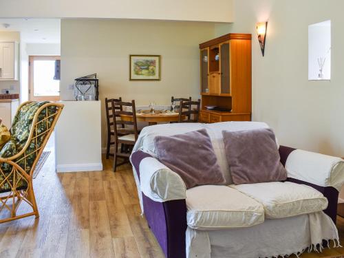 a living room with a couch and a kitchen at Cherry Barn in Dufton