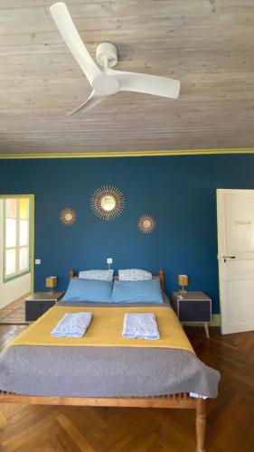 a bedroom with a bed with a ceiling fan at A l'ombre du Fort in Fuilla