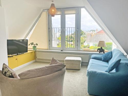 a living room with a blue couch and a tv at 6 Pentire Mews in Newquay