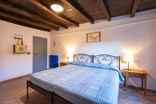 a bedroom with a bed with a blue comforter at Agriturismo Casa Turchetti -Nature & Pool & Relax tra Lunigiana, Nord Toscana e Cinque Terre in Comano