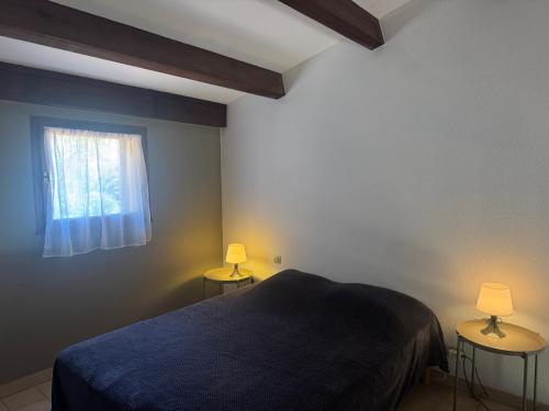 a bedroom with a bed and two lamps on two tables at Résidence Figarella in Propriano