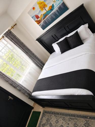 a bedroom with a black and white bed and a window at Eldo oasis in Eldoret