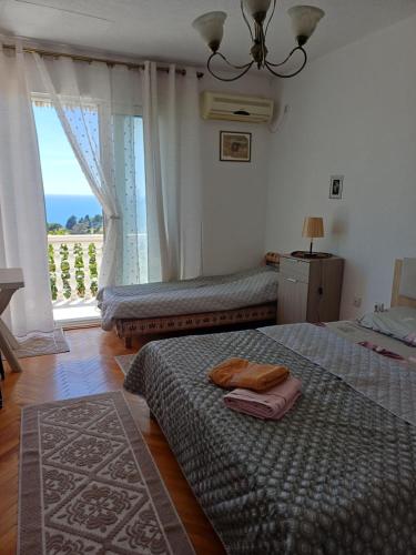 a bedroom with two beds and a large window at Tina Rooms in Ulcinj