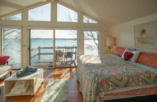 a bedroom with a bed and a view of the water at Lovely Lakeside Lodge in Canandaigua
