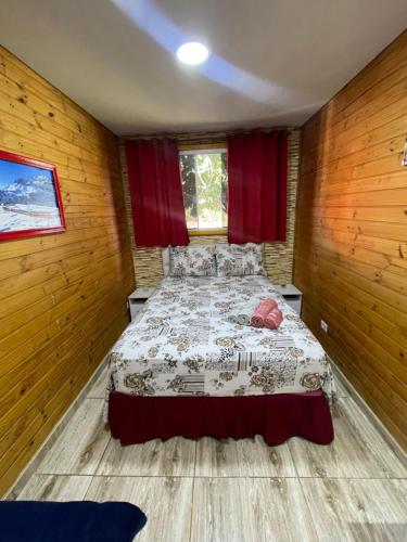 a bedroom with a bed in a room with wooden walls at Swiss Chalets - Thermas Water Park in Águas de São Pedro