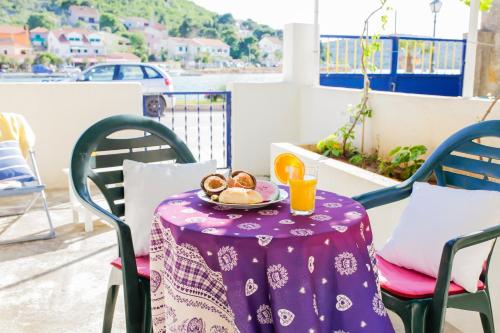 a table with a purple table cloth and a plate of food at Apartment Mihovil 308 in Tisno
