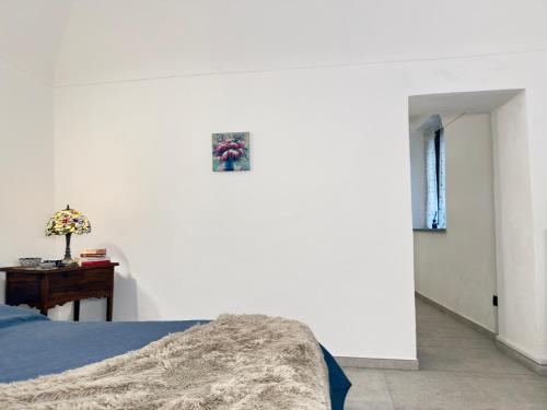 a bedroom with a bed and a table with a picture on the wall at Fuga nel borgo in Avigliana