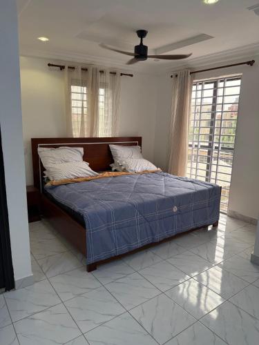 a bed in a bedroom with a ceiling fan at Asibbey Lodge in Maijaw