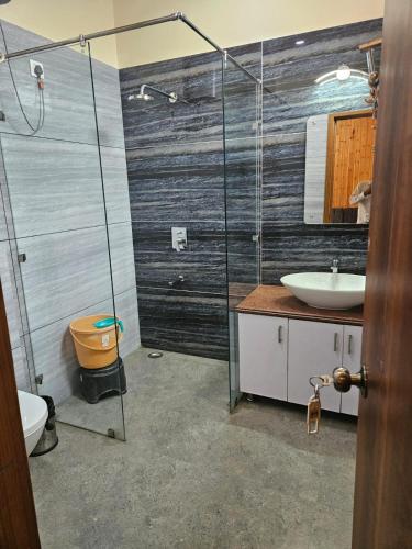 a bathroom with a shower and a toilet and a sink at Vasant Corbett Resort By Mannat in Rāmnagar