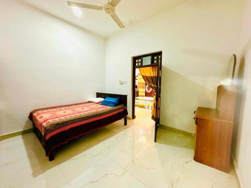 a bedroom with a bed in a room with a mirror at Cleopatra villa in Kattankudi
