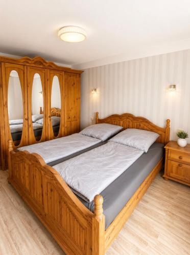 a large wooden bed in a bedroom with wooden furniture at Ferienwohnung AM PETER in Gotha