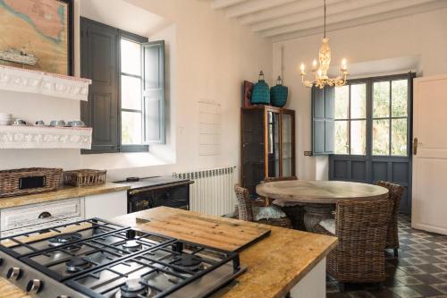 a kitchen with a stove and a table at Villa Station by Cassai in Ses Salines