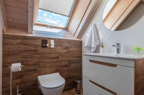 a bathroom with a toilet and a sink and a window at Osada Gorczański Zakątek in Nowy Targ