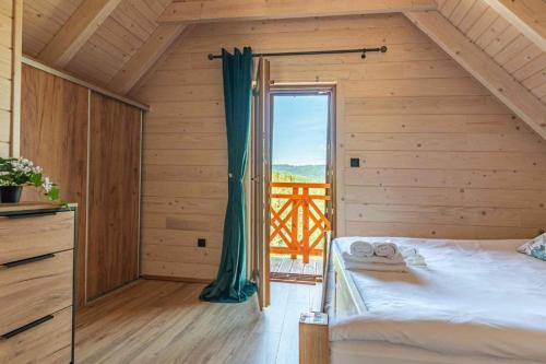 a bedroom with a bed and a large window at Osada Gorczański Zakątek in Nowy Targ