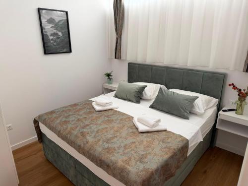 a bedroom with a large bed with two pillows on it at The White House Split in Split