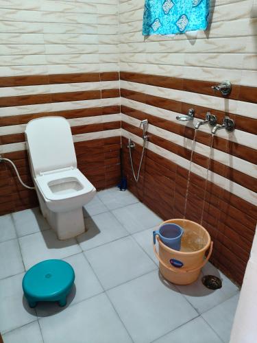 a bathroom with a toilet and a bucket at Hotel B M AND SONS in Phata