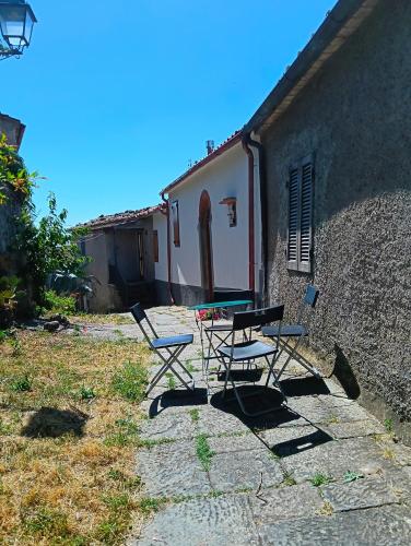 two chairs and a table in front of a building at La Salvia in Scansano