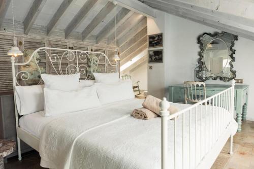 a bedroom with a white bed and a mirror at Villa Station by Cassai in Ses Salines