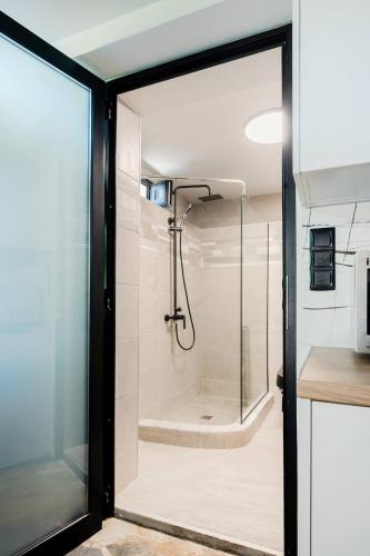 a shower with a glass door in a bathroom at Lemon Tree Villa in Chalkida