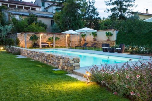 a swimming pool in a yard with a stone wall at Albergo Stella in Casciana Terme