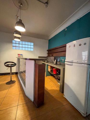 a kitchen with a white refrigerator and a table at Hostel rivendell lima in Lima