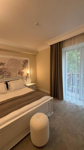 a bedroom with a bed and a chair and a window at Sherwood Hotel in Dovgomostys”ka