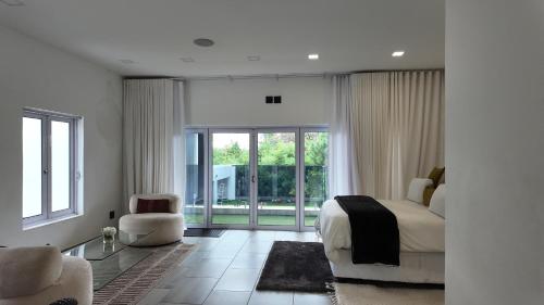 a bedroom with a bed and a large window at Lora Gardens in Chartwell