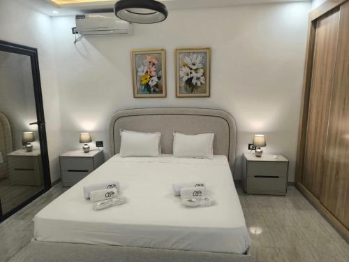 a bedroom with a white bed with two towels on it at Prestige Pool Retreat in Hammamet