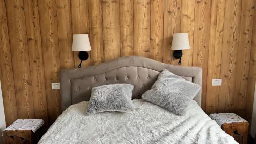 a bedroom with a bed with two pillows and two lamps at Charming apartment pool, SPA, sauna, CIR VDA - AYAS - 0005- in Champoluc