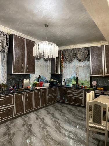 a kitchen with wooden cabinets and a chandelier at Aura in Dzerzhinskoye