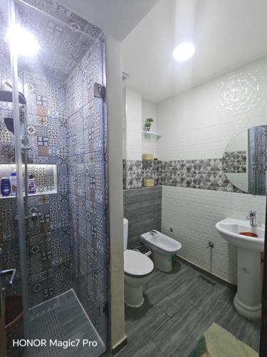 a bathroom with a shower and a toilet and a sink at Ouida App in Oujda