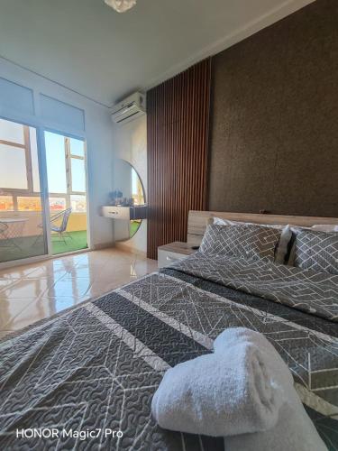 a bedroom with a bed and a large window at Ouida App in Oujda