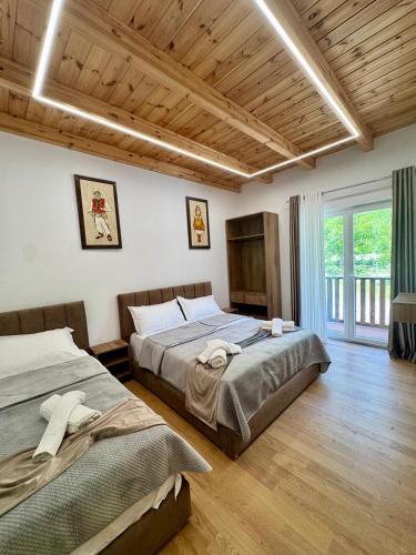 a bedroom with two beds and a large window at Old Mill Heritage Hotel in Ndërlysaj