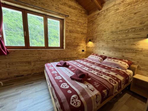 a bedroom with a bed in a wooden cabin at Appartamento Grande Cervino - Il Lupo Affitta in Antey-Saint-André