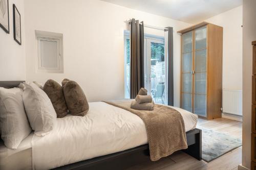 a bedroom with a white bed with pillows at Modern 3 Bed Flat - 3 En-Suites - Parking - near Wembley in Edgware