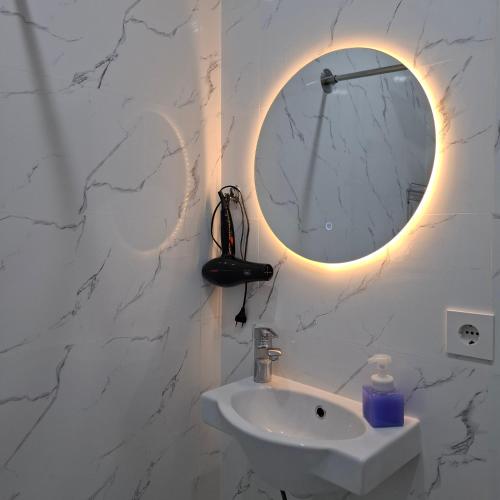 a bathroom with a white sink and a mirror at Byrabau Tauwer in Shchūchīnsk